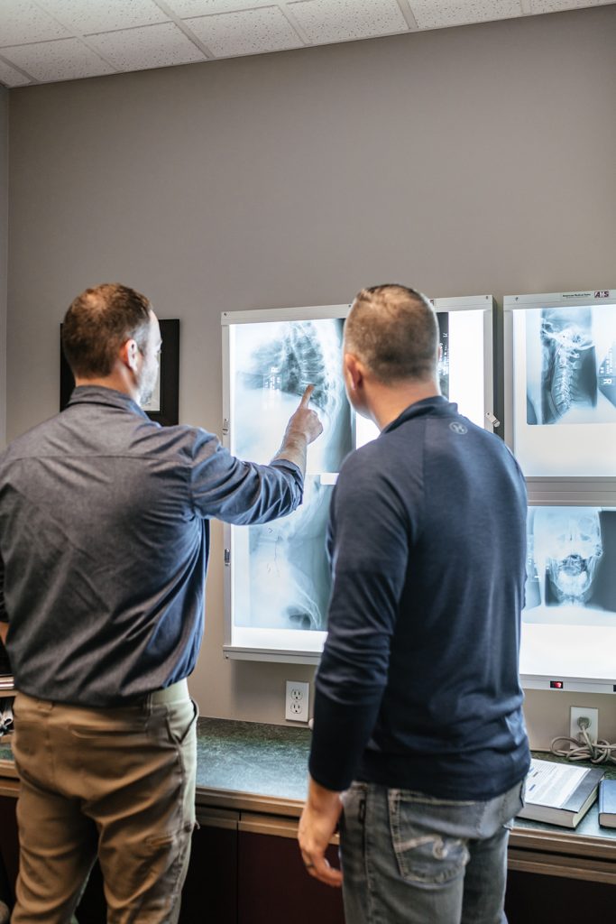 Dr. Bell pointing out degenerative disc disease on X-Rays