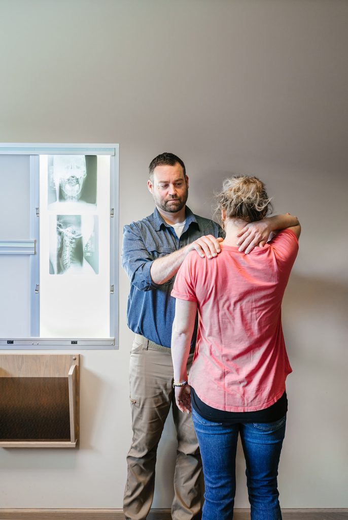 Dr. Bell chiropractor inspecting auto injuries on a patient - Chiropractic Care For Injuries