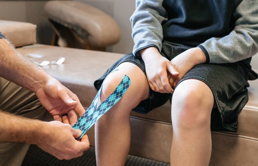 Dr. Bell taping up a Childs knee with Kinesio Tape